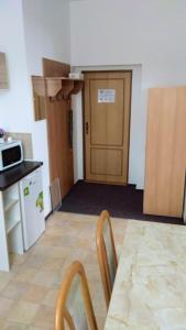 a kitchen with a table and chairs and a door at Pension na hranici in Železná Ruda