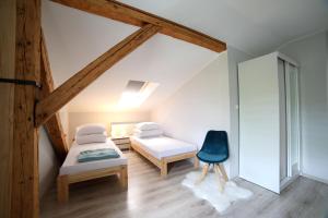 ビストシツァ・クウォツカにあるApartamenty "Kotlina"のベッドルーム1室(ベッド2台、青い椅子付)