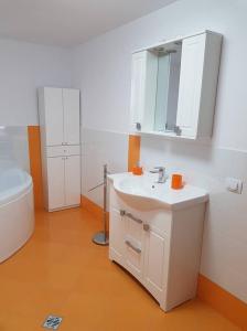 a bathroom with a white sink and a toilet at Pensiunea Casa Rumpel in Gura Humorului