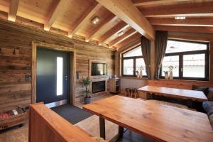 ヴェステンドルフにあるAppartments Weissの木製の壁と木製テーブルが備わるリビングルーム