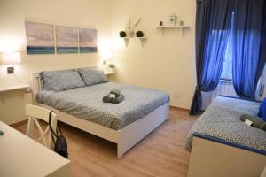 a small bedroom with a bed and blue curtains at Villa Le Garden in Nettuno