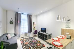 ein kleines Wohnzimmer mit einem Tisch und einem Sofa in der Unterkunft ELLA Apartment in Budapest