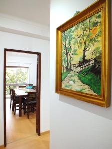 una pintura colgada en una pared junto a un comedor en Clarinha House, en Fátima