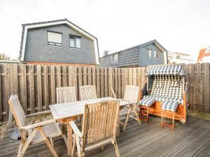 a patio with a table and chairs and a wooden fence at Haus Emil in Cuxhaven