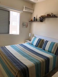 a bedroom with a bed with a striped blanket at MARAÚ Premium - espaço, piscina e ar no Itagua in Ubatuba +11 photos
