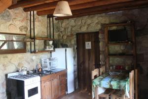 a kitchen with a white refrigerator and a stove at La Casa de Wanda in Villa de Las Rosas