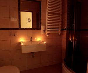 a bathroom with a sink with lights on it at Apartamenty Przy Trakcie Cesarskim in Węgierska Górka +23 photos