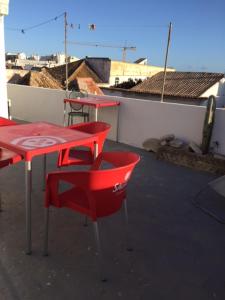 a red table and chairs sitting on a roof at Gast House in Faro