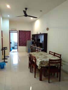a dining room with a table and chairs and a kitchen at ARUWDA Homestay in Ipoh