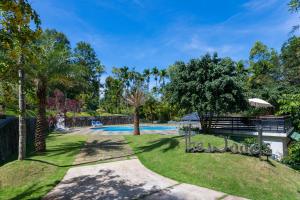 un jardín con piscina y árboles en The Woods Resorts Wayanad, en Sultan Bathery