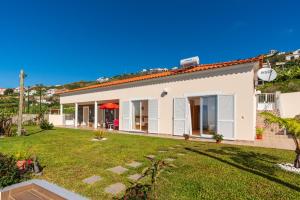 a white house with a yard at Casa Sol e Vista in Arco da Calheta