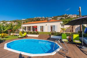 a swimming pool in the backyard of a house at Casa Sol e Vista in Arco da Calheta