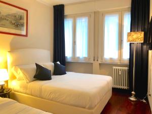 Schlafzimmer mit einem Bett mit weißer Bettwäsche und blauen Kissen in der Unterkunft Ponte Vecchio View Luxury Apartment in Florenz