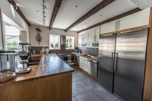 uma grande cozinha com um frigorífico de aço inoxidável em Toftegården Guesthouse - Rooms em Skagen