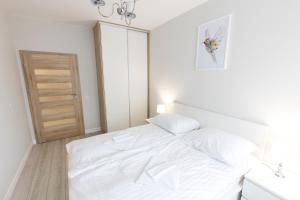 Un pat sau paturi într-o cameră la Apartament 4k Nautica Szczecin