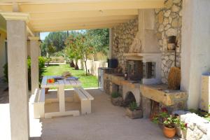 un patio al aire libre con mesa y horno de piedra en Eleftheria Apartments, en Vlachata