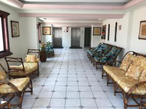 a hallway with couches and chairs in a building at Ed.Valéria IIPraia Grande in Praia Grande