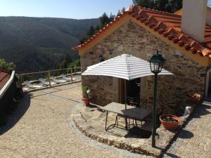 un patio con mesa y sombrilla en Quinta da Gaiya, en Talhadas
