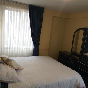 1 dormitorio con cama con espejo y ventana en IMPERIAL Apartamento, en La Paz
