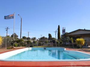 a small pool in a yard with a fence at cross roads motel in Cobar