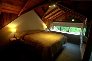1 dormitorio con 1 cama en una habitación con ventana en Casa La Veleta en San Martín de los Andes