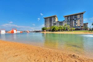 a beach with buildings in the background with the water at Darwin Waterfront Short Stay Apartments in Darwin