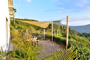 un jardín con una valla, una mesa y una tienda de campaña en Monte Abi Mirador en Chaguaní