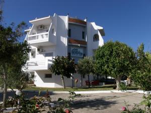 a white building with trees in front of it at Megim Hotel in Palaiochora