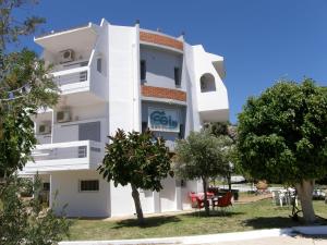 a white building with trees in front of it at Megim Hotel in Palaiochora