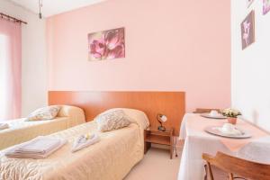 リド・ディ・オスティアにあるB&B Soggiorno Di Ostiaのベッド2台とテーブルが備わるホテルルームです。