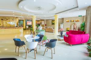 a lobby with pink and blue chairs and tables at 3MG Lakeside Hotel in Hai Phong