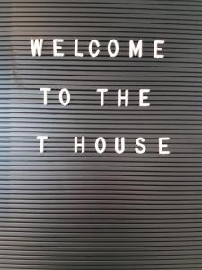 布什米爾斯的住宿－The T House，金属车库门,上面写着欢迎进房子的话
