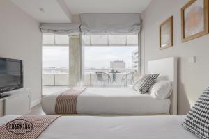 two beds in a room with a window and a tv at Charming Eurobuilding 2 Exclusive in Madrid