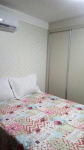 a bedroom with a bed with a floral quilt on it at FLAT EM INTERMARES in Cabedelo