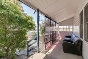 a balcony with a couch on the side of a house at Beacon Cottage in Lake Tyers