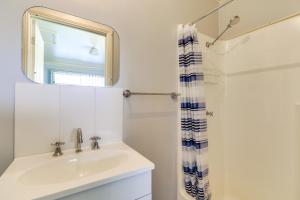 a bathroom with a sink and a mirror and a shower at Beacon Cottage in Lake Tyers +14 photos