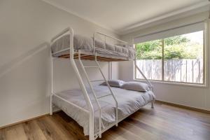 1 dormitorio con 2 literas y ventana en Outlook Views, en Lake Tyers