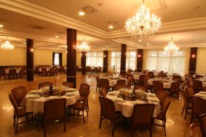 a banquet hall with tables and chairs and a chandelier at Hotel nad Wigrami in Gawrych Ruda