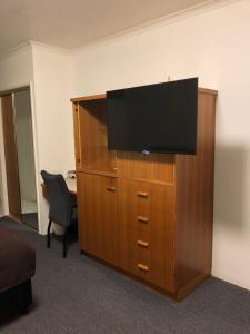 a large entertainment center with a flat screen tv on top at Best Western Cattle City Motor Inn in Rockhampton