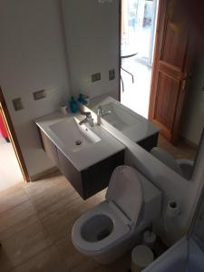 a bathroom with a sink and a toilet and a mirror at Alojamiento Independiente in Zapallar