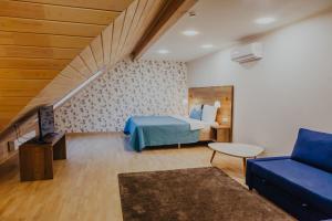 1 dormitorio con 1 cama y 1 sofá azul en Ruchii UDachi, en Belokurikha
