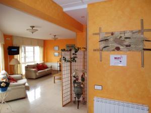 a living room with orange walls and a shelf at Hotel Los Juncos in Noja