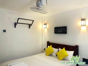 1 dormitorio con 1 cama con almohadas amarillas en The Green Garden en Dambulla