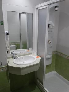 a bathroom with a sink and a shower at Hotel Los Juncos in Noja +28 photos
