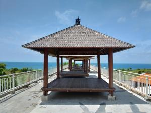 einen Pavillon auf einer Brücke mit dem Meer in der Unterkunft Balangan Paradise Hostel and Restaurant in Jimbaran