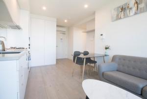 a kitchen and a living room with a couch and a table at Platinum City Serviced Apartments in Melbourne