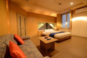 um quarto de hotel com uma cama e um sofá em Hotel Tiffany (Adult Only) em Asahikawa