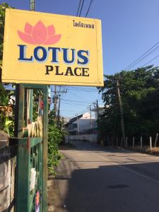 ein Schild für einen Lotusplatz am Straßenrand in der Unterkunft Lotus Place Sukhothai in Sukhothai