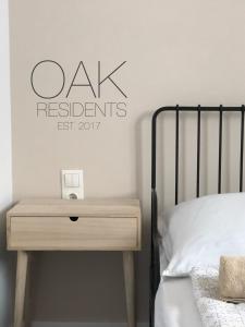 a bedroom with a bed with a wooden nightstand next to a bed sidx sidx at OAK Residents Siófok in Siófok