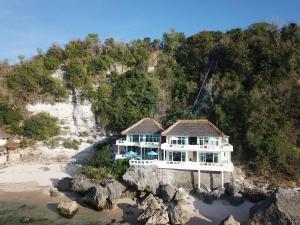an aerial view of a house on a rocky beach at Mandala The Rocks in Uluwatu